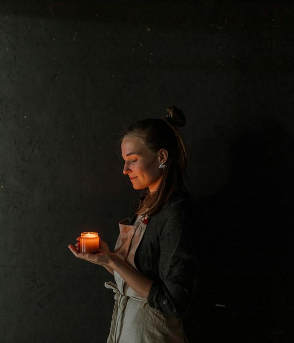 Woman meditating peacefully in a softly lit room, embodying inner calm.